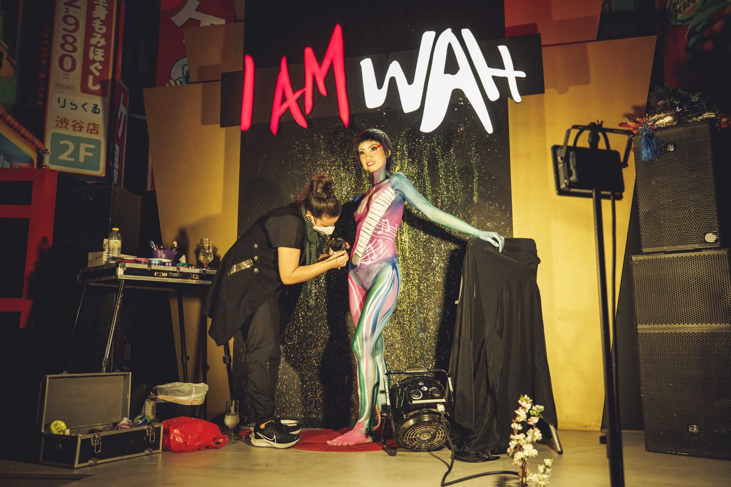 artista haciendo body painting en el food hall de wah show