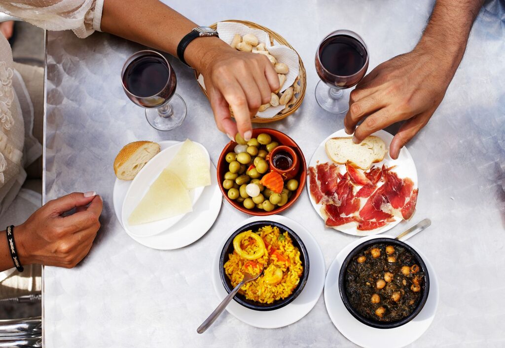 Tapas y comida típica española compartidas en una mesa durante un plan gastronómico en Madrid