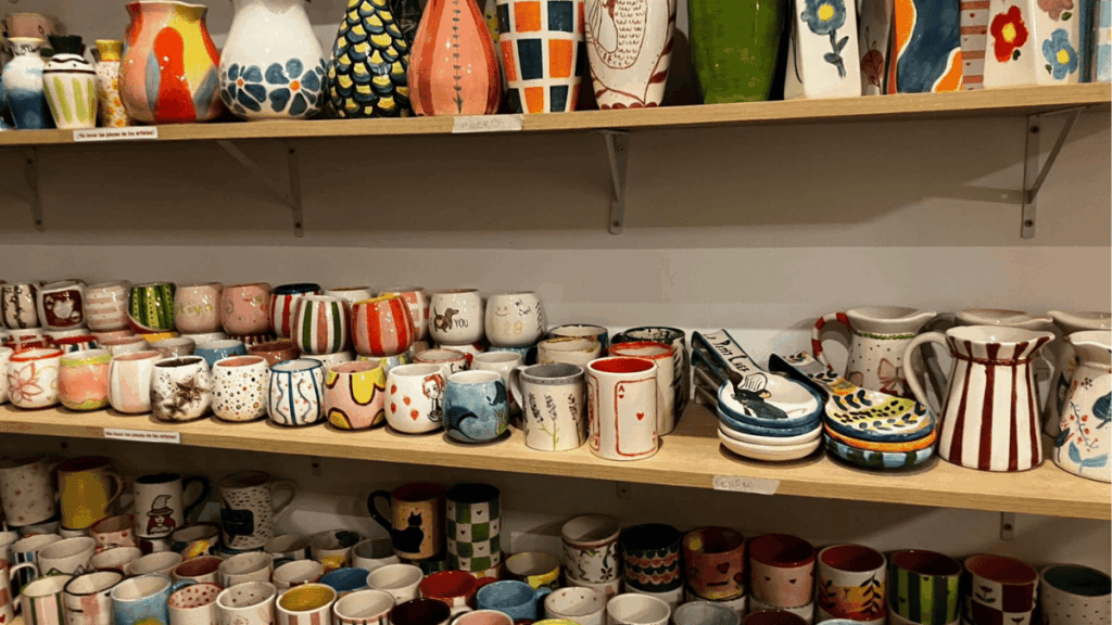 Estantería con tazas y jarrones de cerámica pintados a mano