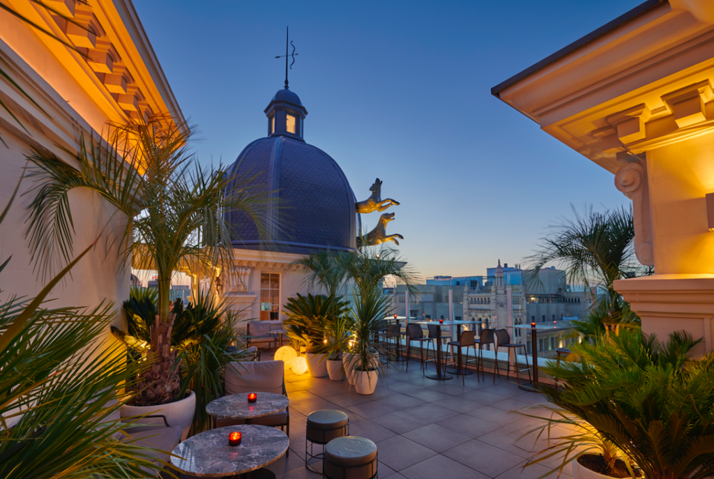 Terraza con vistas al skyline de Madrid al atardecer con iluminación ambiental y un ambiente exclusivo