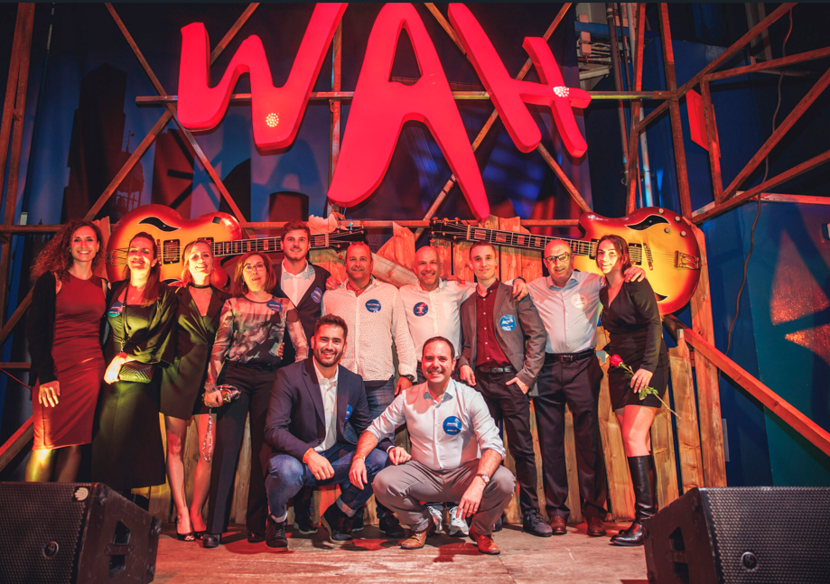 Equipo de empresa posando en el escenario de WAH tras una actividad para motivar y reconocer al equipo