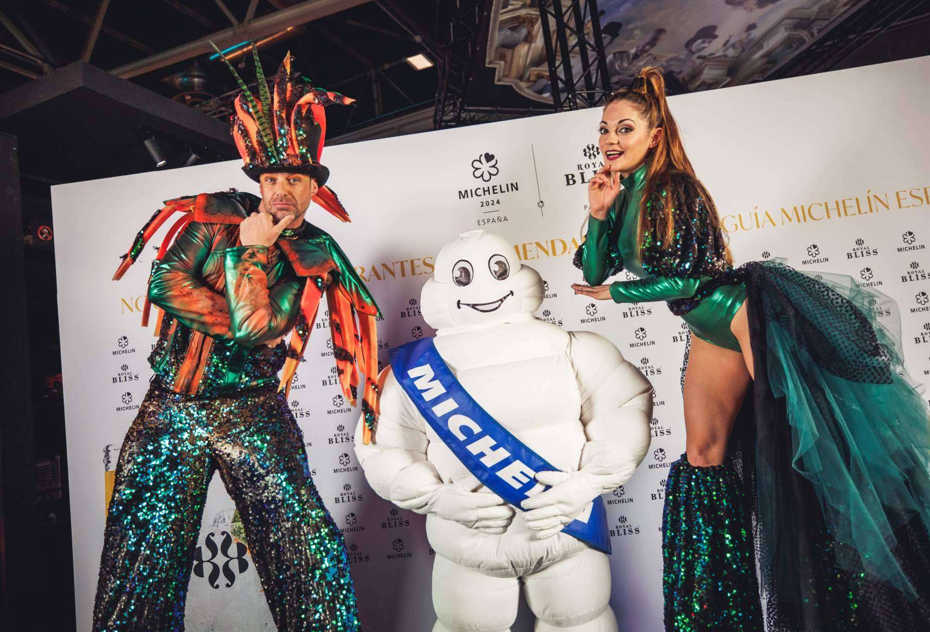 Mascota Michelin Man flanqueada por animadores caracterizados en la Gala Guía Michelin España patrocinada por Royal Bliss