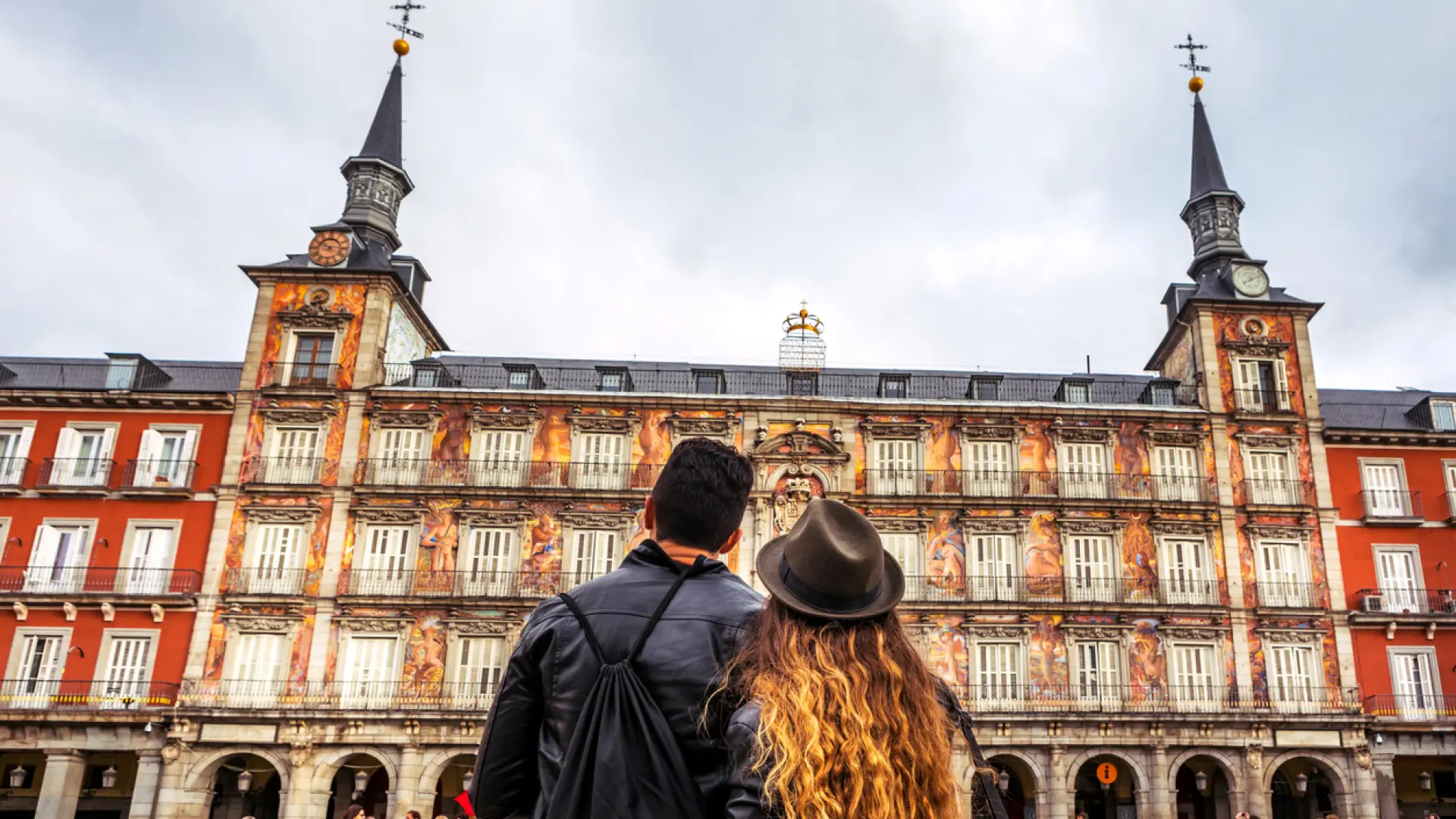 Pareja de espaldas contemplando la fachada de la Casa de la Panadería en la Plaza Mayor de Madrid